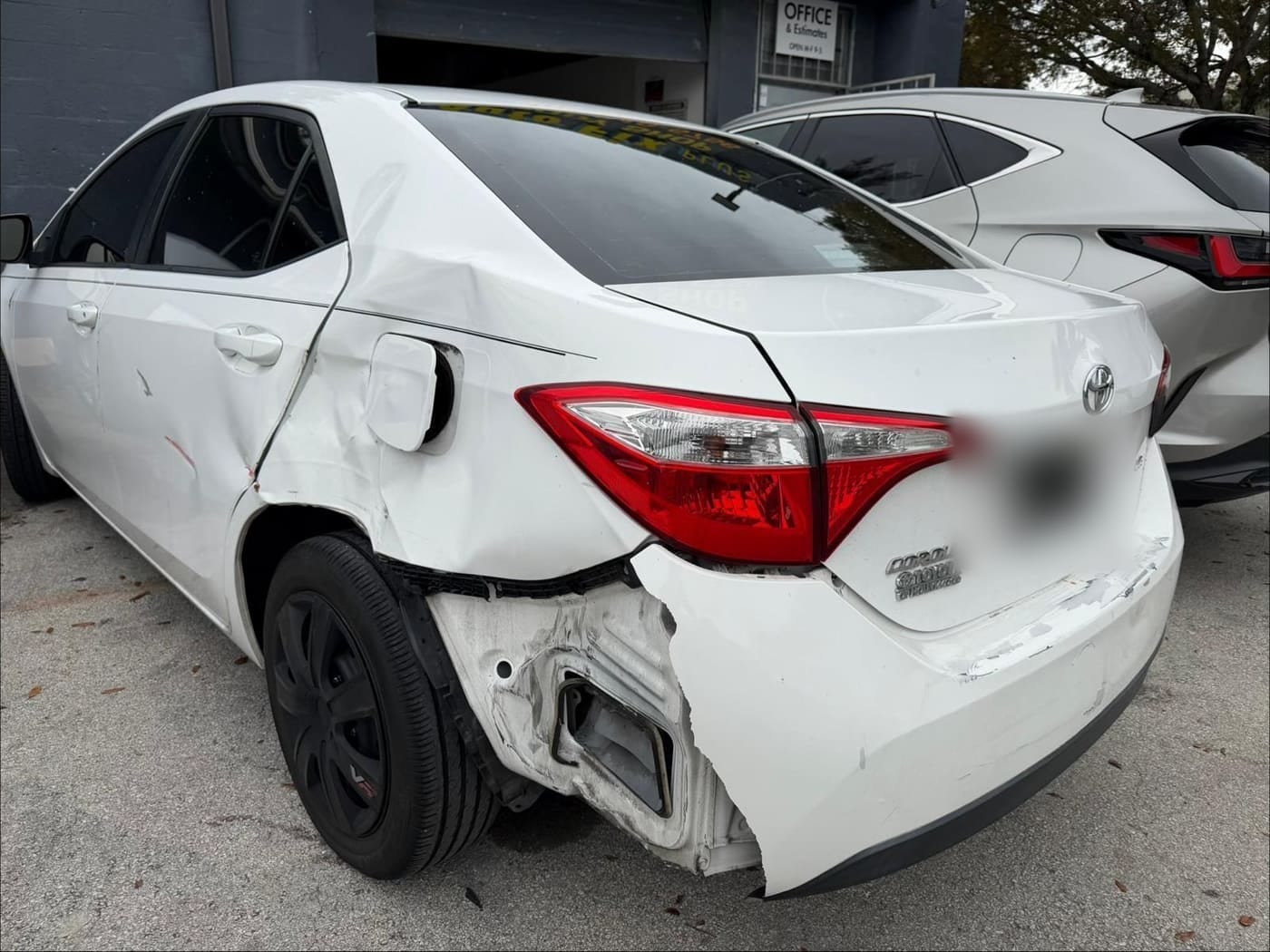 The same Toyota Corolla rear end before repair, showing collision damage